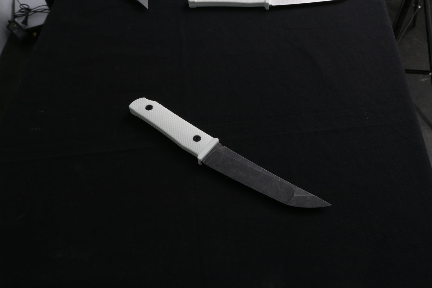 Knife with a white handle on a dark surface