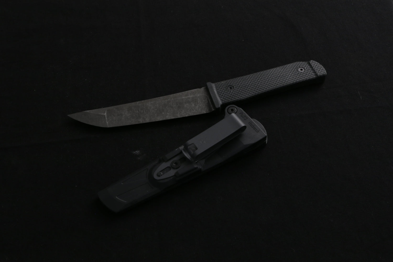 Black knife with sheath on a black surface
