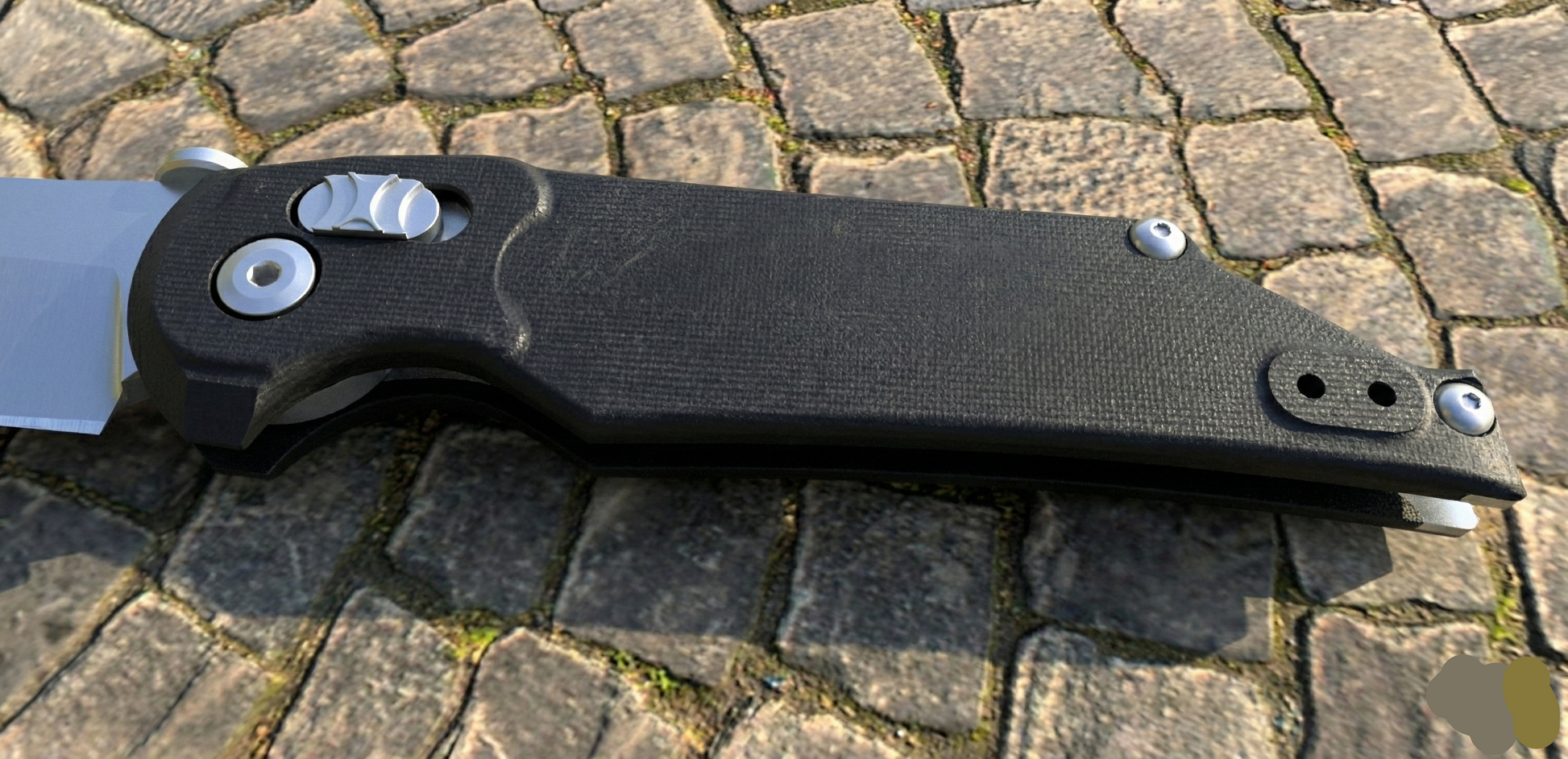 Folding knife with a black handle on a stone pavement