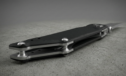 Black and silver pocket knife on a textured surface with a neutral background